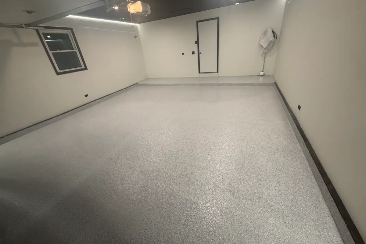 Finished polyurea flake garage floor in a Schist blend with a coated wall base, over older cracked concrete in Palatine, Illinois