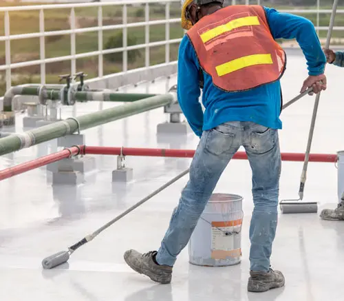 man coating commercial concrete floor