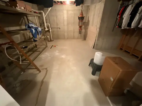 Basement floor before coating, bare concrete with a long visible crack