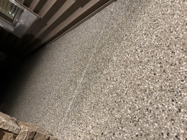 Coated walkway along siding showing Creekbed flake blend over repaired concrete