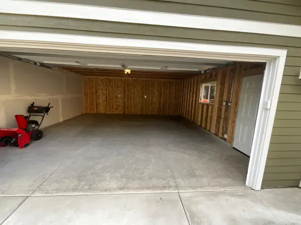 Before: bare gray concrete garage floor with control joints, ready for coating