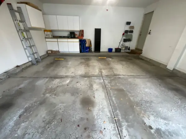 Before: stained, worn two-car garage floor with surface scaling in Buffalo Grove