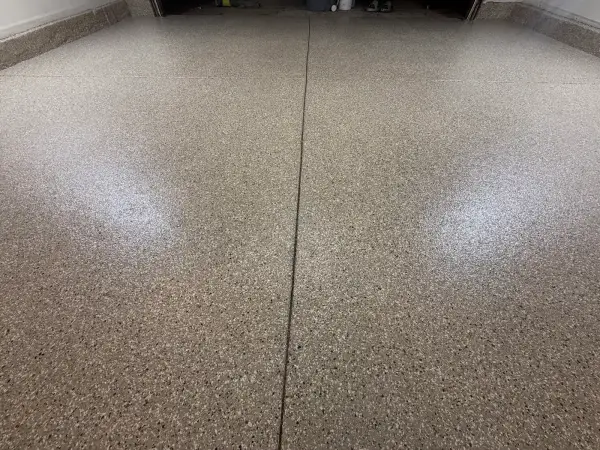 Glossy Creekbed flake polyurea coating across garage floor control joints