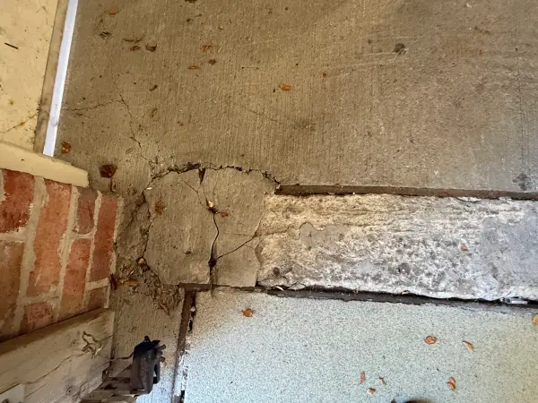 Cracked and broken concrete at the garage entry threshold needing repair