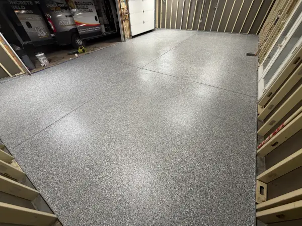 Finished gray gravel flake polyurea garage floor with glossy topcoat