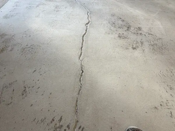 Long crack running across ground concrete garage floor during prep