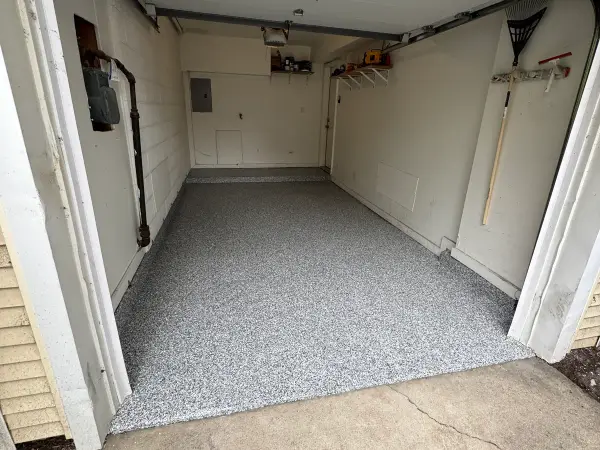 Finished polyurea garage floor with gravel flake blend seen from the driveway
