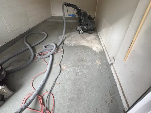 Grinding the old painted garage floor with dust-collection hoses in place