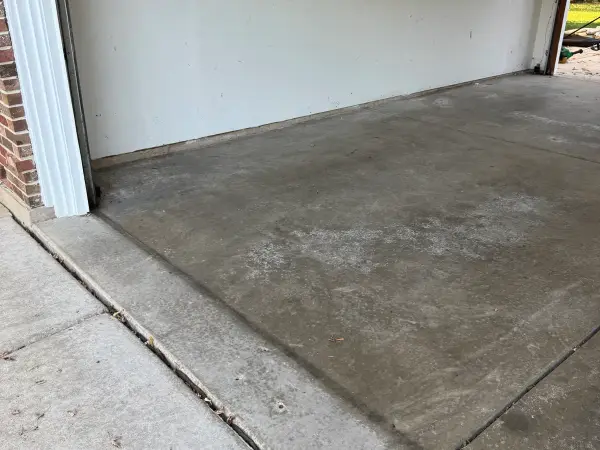 Before: worn, stained bare concrete garage floor near the door