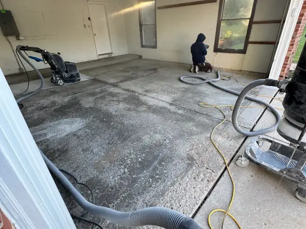 Grinding and crack prep underway across the two-car garage floor