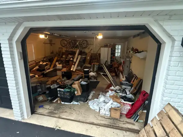 Cluttered garage with worn bare concrete floor before coating work began