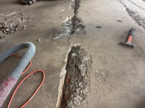 Cracks opened and widened along the garage floor during repair prep