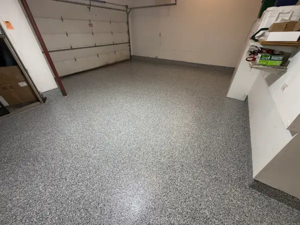 Finished garage floor with gravel flake polyurea coating and coved edges