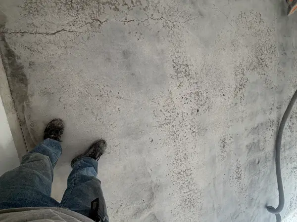 Ground concrete garage floor showing a long crack before repair