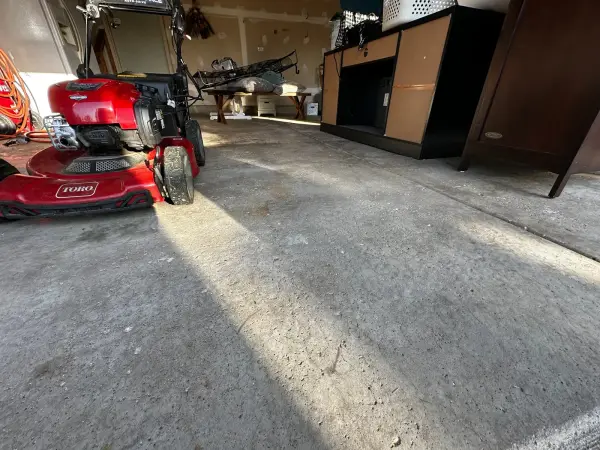 Before: worn bare concrete garage floor with dust and light stains