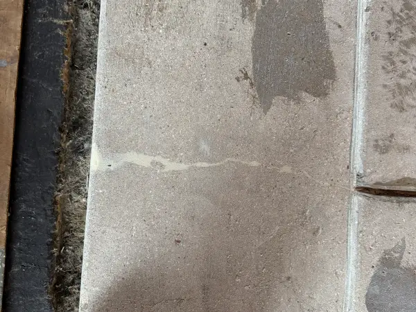 Ground concrete slab edge with filled crack ready for coating